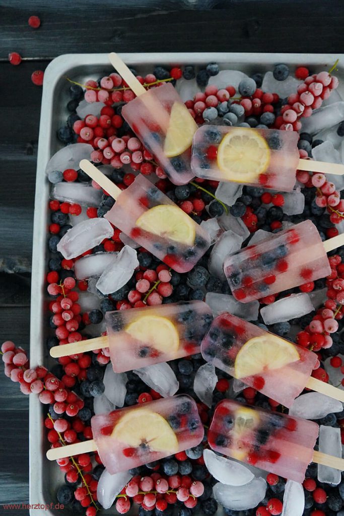 Erdbeer-Wassereis Popsicles mit bunten Früchten